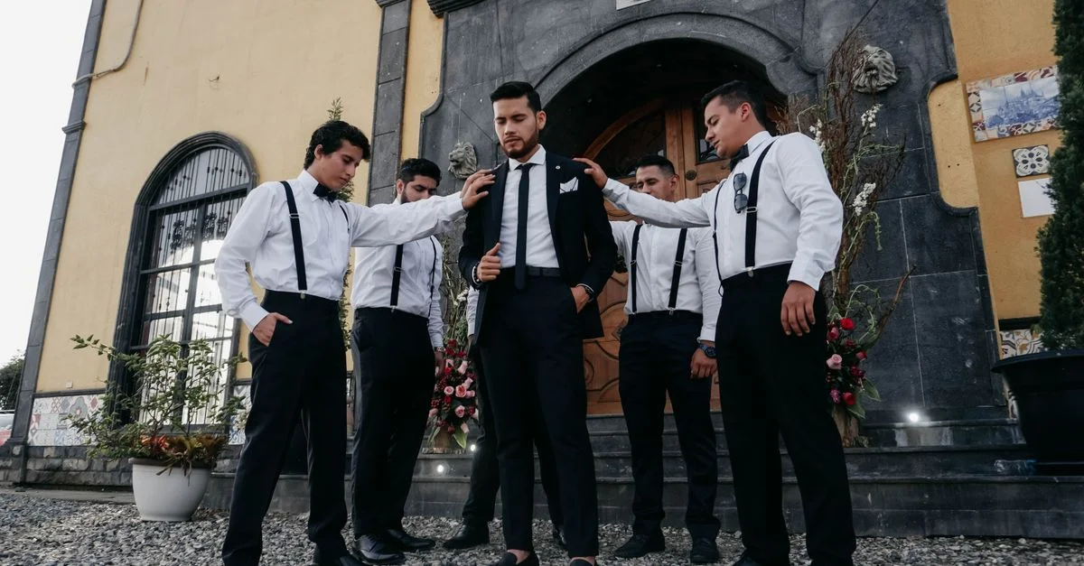 Novio con sus padrinos en trajes elegantes preparándose para la boda al aire libre en Ecuador.